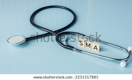 SMA, spinal muscular atrophy, Written on wooden blocks, a rare disease in which, due to a genetic defect, neurons in the spinal cord responsible for muscle contraction and relaxation gradually die Royalty-Free Stock Photo #2231317885