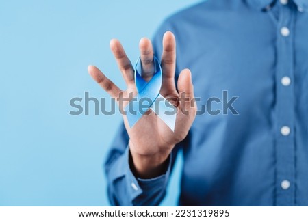 men hands showing Blue ribbon for supporting people living and illness, Colon cancer, Colorectal cancer, Child Abuse awareness, world diabetes day, International Men's Day Royalty-Free Stock Photo #2231319895