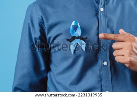 men hands showing Blue ribbon with moustache for supporting people living and illness, Colon cancer, Colorectal cancer, Child Abuse awareness, world diabetes day, International Men's Day