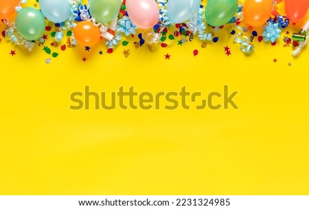 Birthday background top view. Balloons and various party decorations on a yellow background with copy space