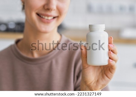 Happy young caucasian woman holding bottle of dietary supplements or vitamins in her hands. Close up. Healthy lifestyle concept Royalty-Free Stock Photo #2231327149