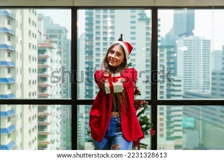 Happy young woman holding Christmas gift box on Christmas party day at home. Merry Christmas and Happy Holidays