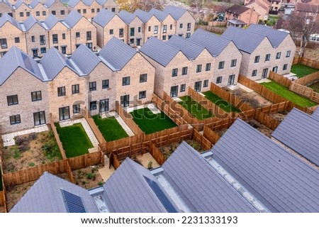 Aerial view of rows of new build modular terraced houses in the UK with characterless design for first time buyers Royalty-Free Stock Photo #2231333193