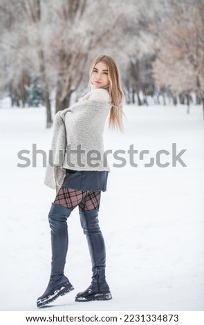 portrait of young beautiful woman posing in winter park