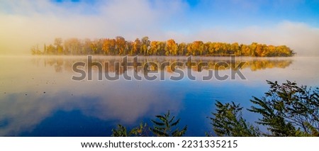 Autumn forest on the riverside, marvel at the amazing views of the island. Fall foliage in Connecticut, Middletown, near Hurd State Park Royalty-Free Stock Photo #2231335215