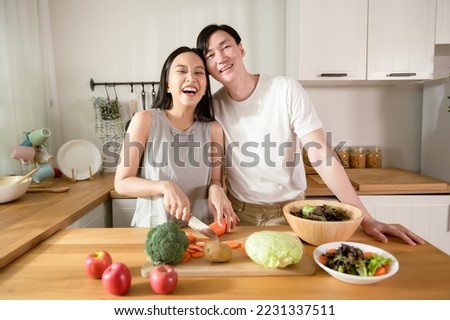 An Asian young couple enjoy cooking with healthy vegetables and fruits ingredients in kitchen at home , healthy wellness lifestyle concept. Royalty-Free Stock Photo #2231337511