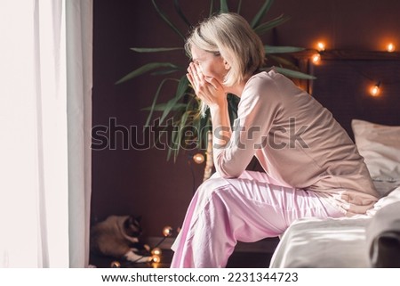 After sleepless night sad 40s woman got up sit on bed thinking, lost in sad thoughts about irreparable mistake decision about abortion, feeling remorse, break up in relations, divorce concept Royalty-Free Stock Photo #2231344723