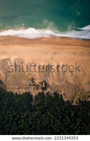 Aerial view of a church on the French beach lined with dunes and a rough ocean (aerial view)