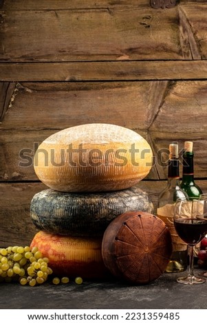 Cheese wheel and wine on a wooden background. farmer market. place for text.
