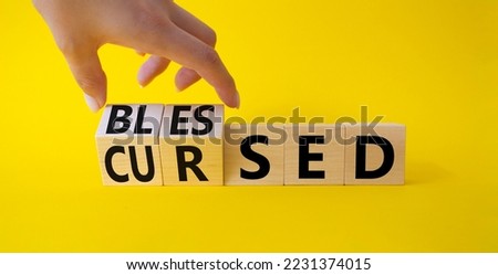 Blessed vs Cursed word symbol. Businessman Hand turns cubes with word Cursed and changes it to word Blessed. Beautiful yellow background. Religious and Blessed vs Cursed concept