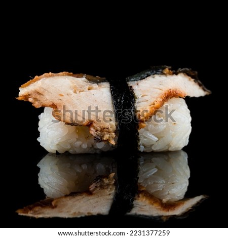 Unagi nigiri sushi or eel nigirizushi with toppings of fresh fish. Nigiri sushi with rice and smoked eel on black. Royalty-Free Stock Photo #2231377259