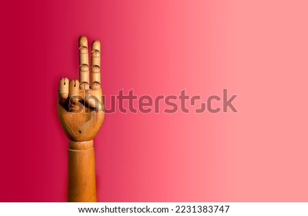 Wooden hand on a red background. Close-up of a wooden human hand - a prosthesis,