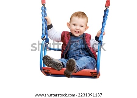 Happy toddler baby boy rides on a swing, isolated on a white background. Smiling child swinging on the playground, kid aged one year