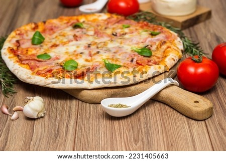 Freshly baked pizza with ham, tomato, and cheese