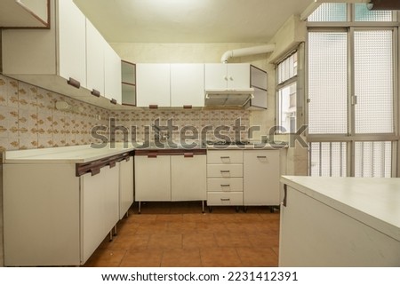 Kitchen with old white furniture, aluminum partitions with translucent glass and vintage tiled walls Royalty-Free Stock Photo #2231412391