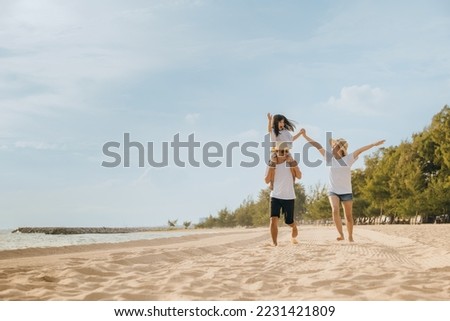 Family day. Happy family people having fun in summer vacation run on beach, daughter riding on father back and mother running at sand beach, family trip playing together outdoor, traveling in holiday Royalty-Free Stock Photo #2231421809