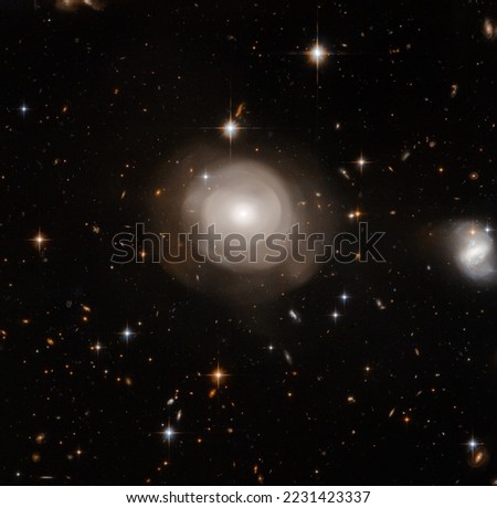 Collision of a cluster of stars creating on big glowing star and distant galaxies in the background. Digitally enhanced. Elements of this image furnished by NASA.