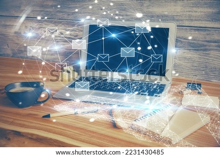 Desktop computer background in office and flying envelops hologram drawing. Double exposure. Electronic mail concept.