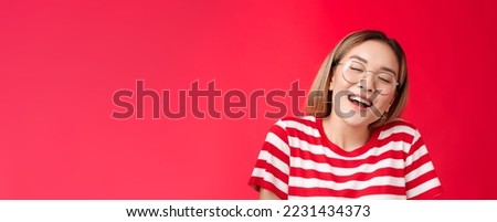Happy dreamy glad asian girl feel stuffed good after eating favorite sandwich, woman wear glasses close eyes delighted smiling broadly opened mouth fantasizing, dreaming tasty burger. Royalty-Free Stock Photo #2231434373