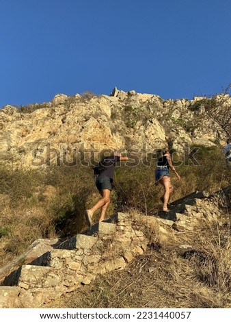 A man and a woman climbing the "999" steps to the top of  the fortress of Palamidi in Nafplio, Peloponnese, Greece