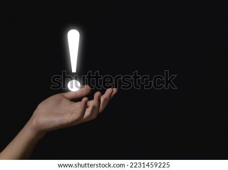 The businessman's hand shows a white exclamation mark. business development concept, error warning, notification, maintenance, and finding a solution. dark background with copy space