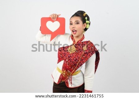 Portrait of Beautiful Woman in Thai Northern Traditional Clothing with card in heart symbol, Pretty Asian woman in Thai Lanna dress hold a heart symbol card in red and white on white background