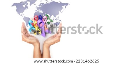 Hand holding covered multi colorful cancer awareness ribbon with world map design for campaign of World Cancer Day banner and background