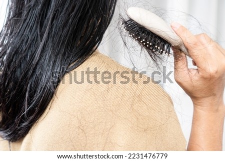woman brushing wet hair with hair loss on comp and shoulder  Royalty-Free Stock Photo #2231476779