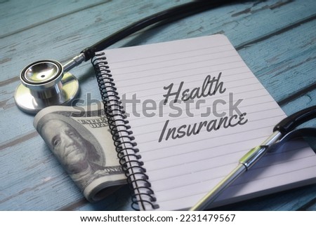 Health Insurance wording with money and stethoscope. Medical protection concept 
