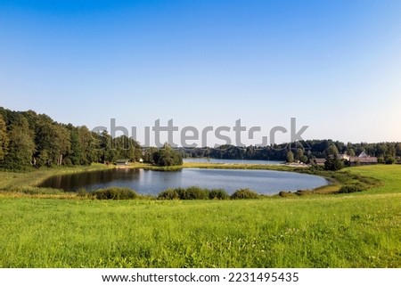 Lake Kaussjärv in Võru county, Estonia. Small lake, green grass. Royalty-Free Stock Photo #2231495435