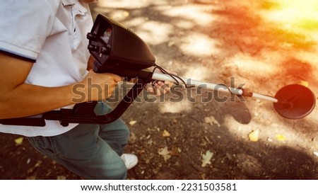a boy with a metal detector in a sunny forest. High quality photo