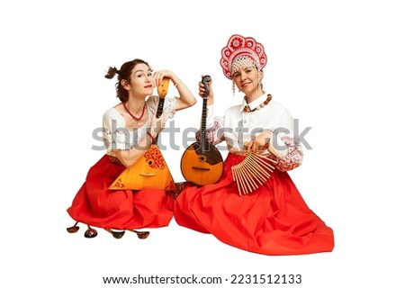 Women musicians in Russian folk dresses with musical instruments, isolated on a white background. Happy artists from Russia in national clothes