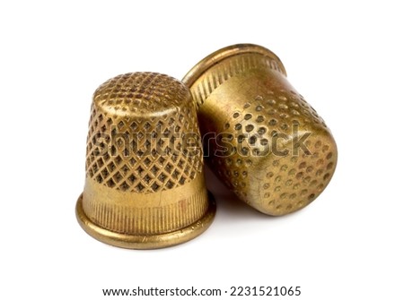 Two antique copper thimbles on a white background. Old thimbles close-up. A selective focus. Royalty-Free Stock Photo #2231521065