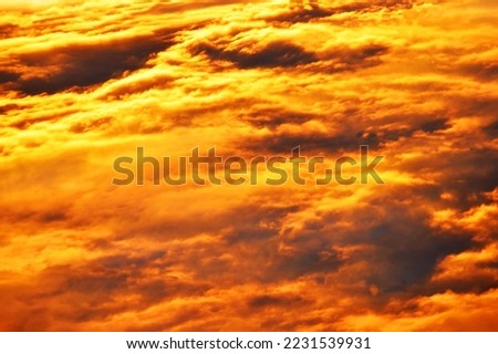 Fiery sunset. Orange-yellow clouds in the summer at sunset. Background and wallpaper.