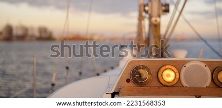 White yacht arriving in port at sunset. Close-up view from the deck to the bow and sails. Dramatic sky after the storm. Baltic sea. Nautical vessel, transportation, service, sport, recreation concepts Royalty-Free Stock Photo #2231568353