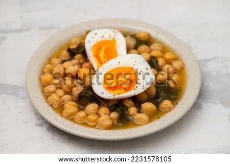 Boiled chickpea with spinach and boiled egg on small plate
