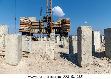 Equipment for installing concrete piles on construction sites. Hammered concrete piles sticking out of the ground at a construction site Royalty-Free Stock Photo #2231581385