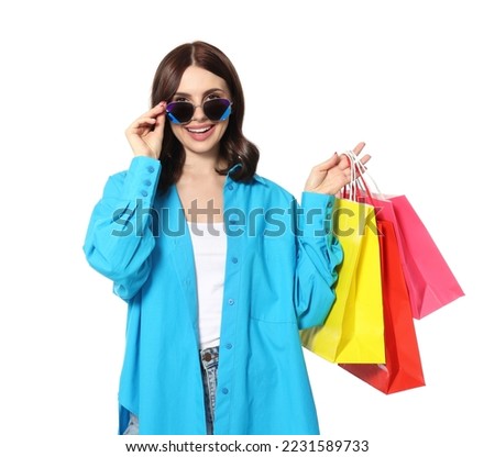 Beautiful young woman with paper shopping bags on white background