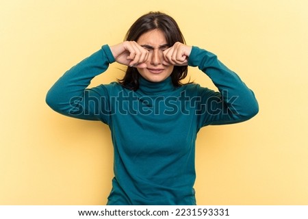 Young Indian woman isolated on yellow background whining and crying disconsolately. Royalty-Free Stock Photo #2231593331