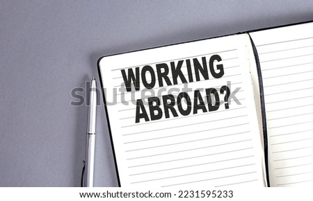 WORKING ABROAD word on notebook with pen