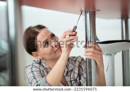woman working on installing assembling furniture table