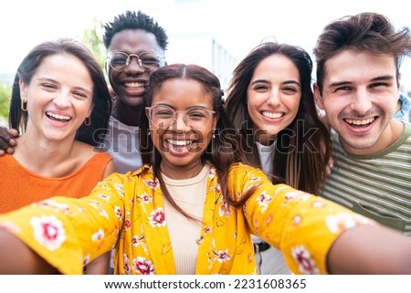 Multicultural friends taking selfie picture outside on city street - Group of young people laughing at camera together. Happy diverse students having fun in college campus. Friendship concept