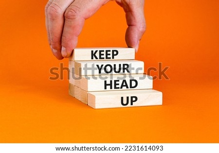 Keep your head up symbol. Concept words Keep your head up on wooden cubes. Beautiful orange table orange background. Businessman hand. Business motivational keep your head up concept. Copy space.