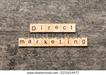Direct marketing word written on wood block. Direct marketing text on cement table for your desing, concept.