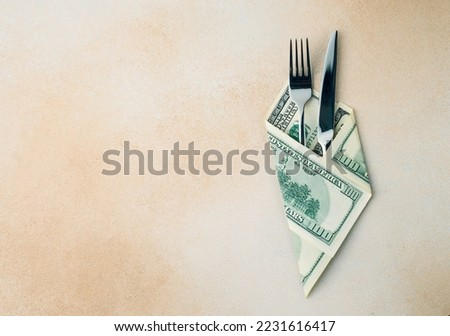 cutlery knife and fork wrapped with dollar bills