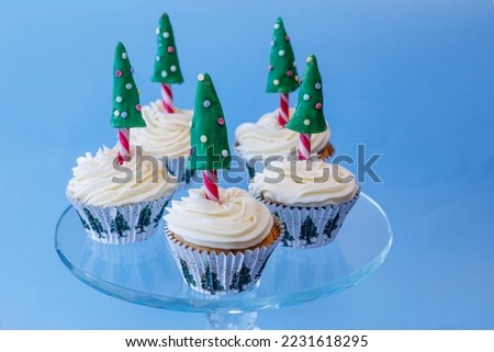 Christmas  Tree Cupcakes, Christmas tree paper cases, vanilla buttercream, red and white striped candy cane tree trunk with green fondant decorated tree. 