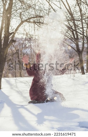 Falling snowflakes scenic photography. Throwing snow. Picture of woman with winter forest on background. High quality wallpaper. Photo concept for ads, travel blog, magazine, article