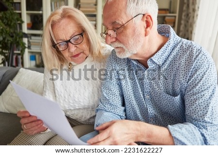 Couple of seniors reading a contract or health care proxy or living will Royalty-Free Stock Photo #2231622227