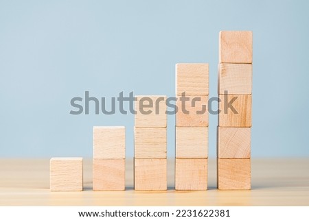 Wooden blocks increasing graph bar, infographic diagram, chart made of wooden blocks over front on blue background
