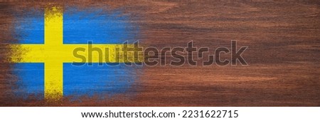 Flag of Sweden. Flag is painted on a wooden surface. Wooden background. Plywood surface. Copy space. Textured creative background